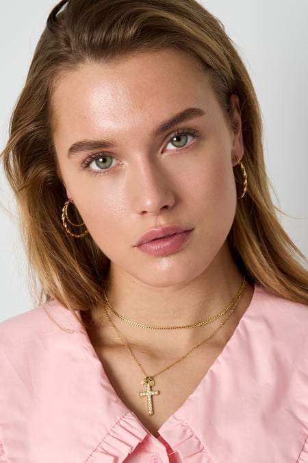 Necklace with decorated cross pendant and charms