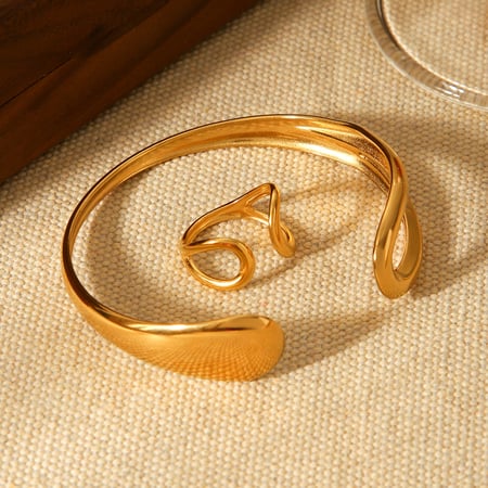 1 brazalete sencillo de acero inoxidable ahuecado de color dorado para mujer.