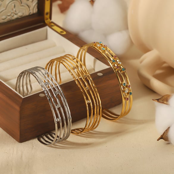 1 par de pulseras abiertas clásicas de moda con circonitas huecas de múltiples líneas en acero inoxidable chapado en oro de 18 quilates.