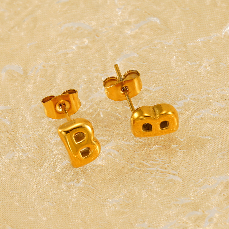 1 par de aretes de botón de acero de titanio chapados en oro de 18 quilates con letras elegantes de serie simple para mujer Imagen3