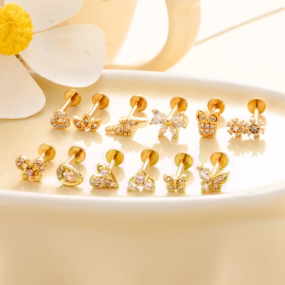 1 par de pendientes de piercing para mujer con circonitas de color cobre y dorado con forma de corazón.
